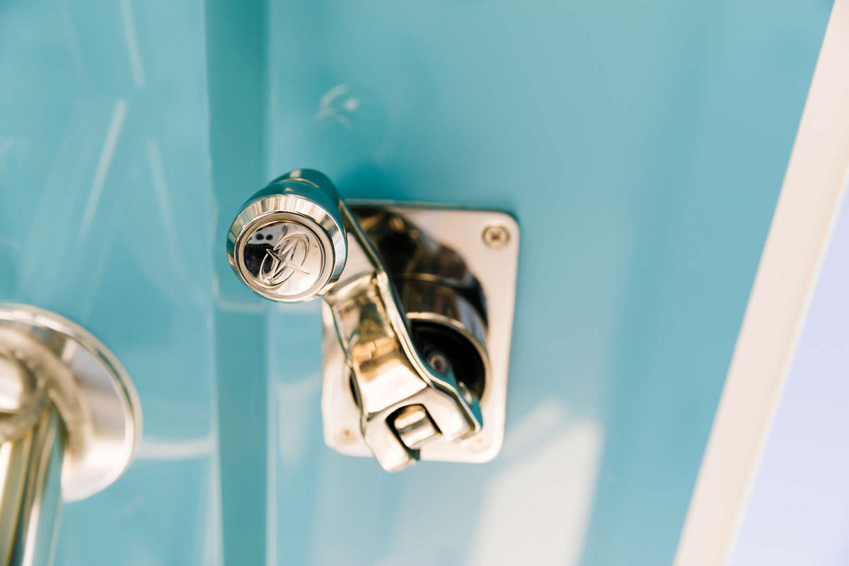 Polished GEMLUX stainless steel handle mounted on a light blue boat console