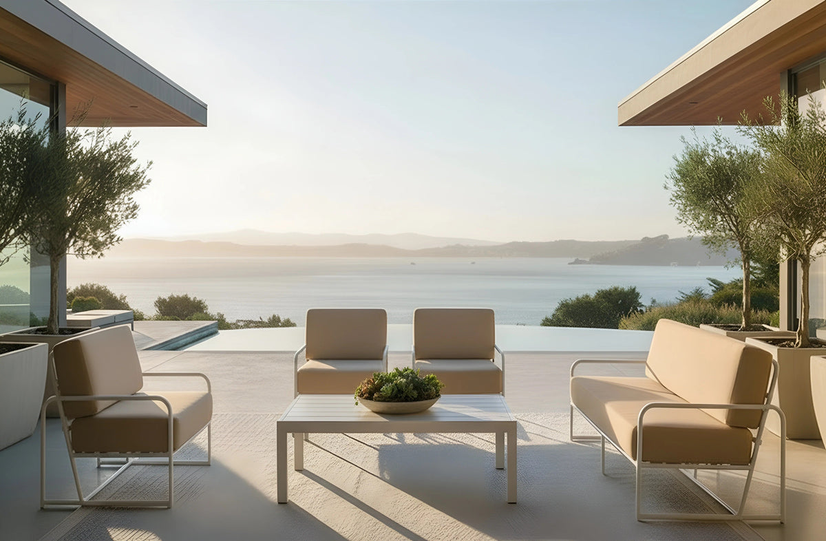 Admiral Outdoor lounge chairs, sofa and coffee table with white aluminum frames on a terrace overlooking the water