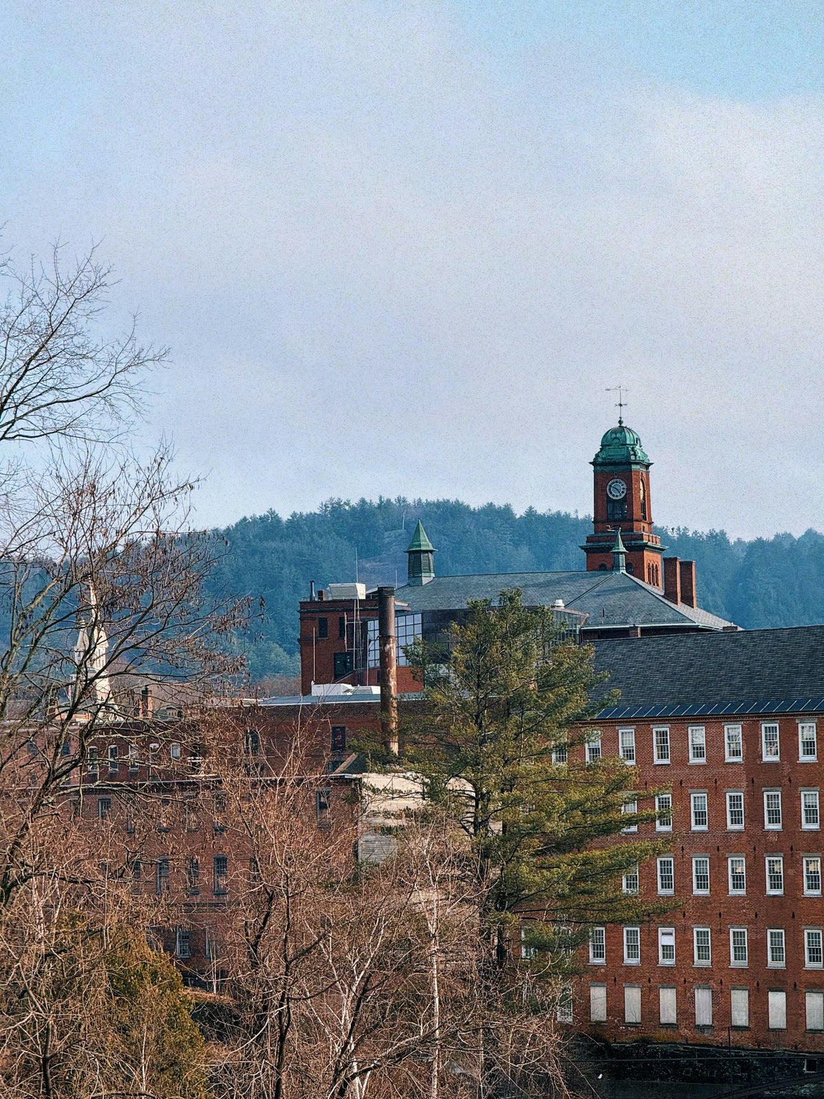 Brick mill buildings in a wooded New England mill town